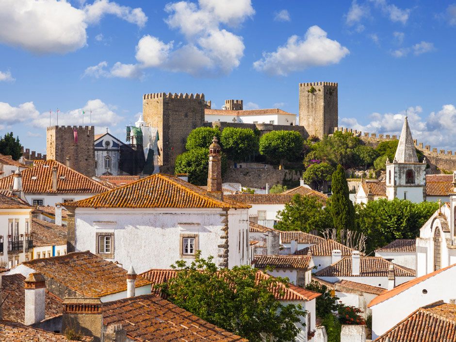The medieval walls and castle of Óbidos above the whitewashed village