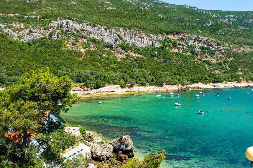 La crique turquoise du Portinho da Arrábida au pied de la verte serra