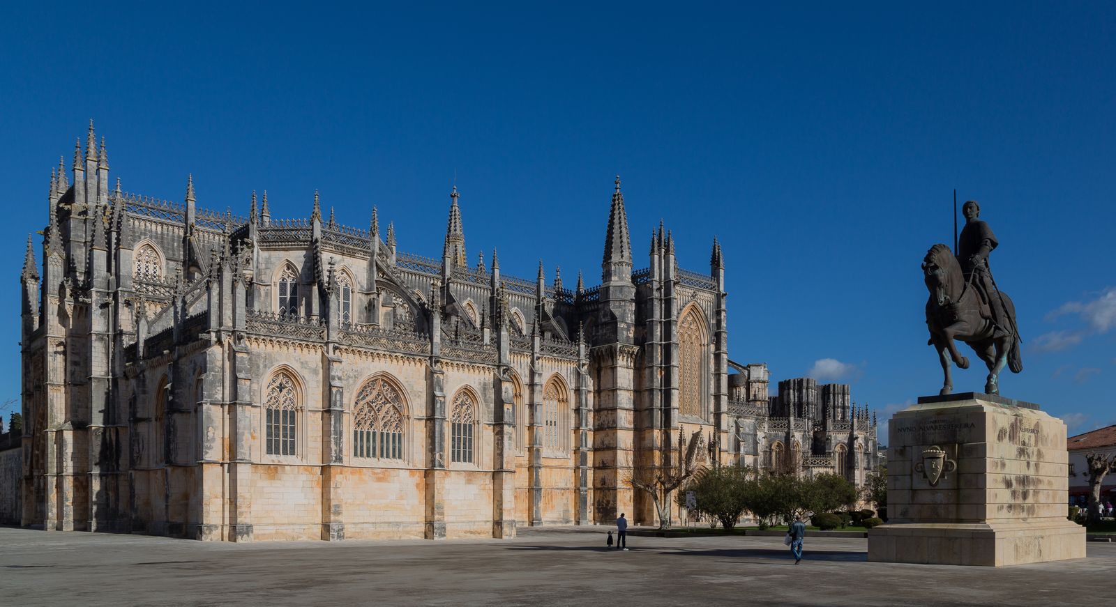 The Gothic west front of the Monastery of Batalha in central Portugal, with the equestrian monument to Nuno Álvares Pereira in the foreground